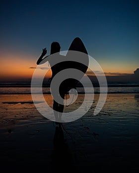 beautiful girl with a surfboard at sunset.