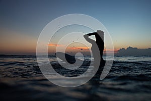 beautiful girl with a surfboard at sunset.