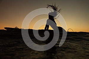 beautiful girl with a surfboard at sunset.