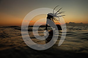 beautiful girl with a surfboard at sunset.