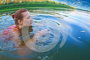Beautiful girl swimming in a river