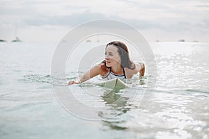 beautiful girl swimming on surfboard