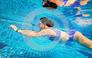 Beautiful girl swimming underwater in pool