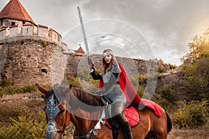 A beautiful girl with a sword in a medieval fantasy suit. A woman in a chain mail, crown, on a horse in combat ammunition. A girl