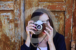 Beautiful girl taking picture with old camera