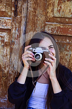 Beautiful girl taking picture with old camera