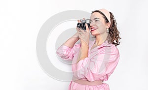 Beautiful girl taking pictures with film camera on white background
