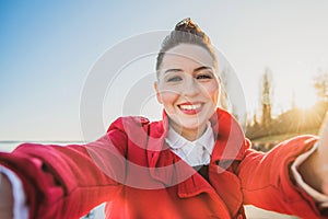 Beautiful girl taking pictures herself at sunset