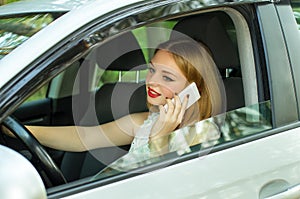 Beautiful girl talking while driving in the car on the phone