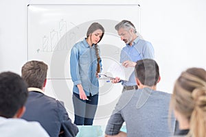 Beautiful girl with teacher solves formula on white board