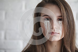 Beautiful girl with tears in her eyes. Young girl with painted t