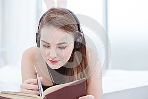 Beautiful girl teen relax at home to reading a book with headphone