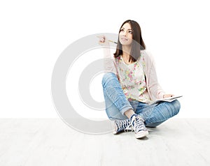 Beautiful girl teenager thinking sitting on floor.