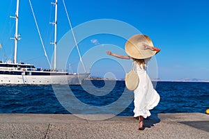 Beautiful girl tourist walking at Spetses marina seaport, Greece