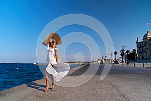 Beautiful girl tourist walking at Spetses marina seaport, Greece