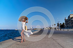 Beautiful girl tourist walking at Spetses marina seaport, Greece