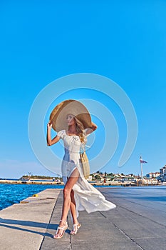 Beautiful girl tourist walking at Spetses marina seaport, Greece