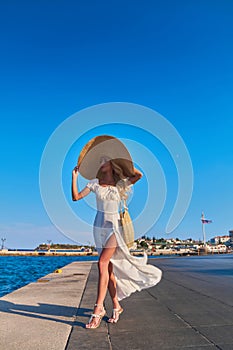 Beautiful girl tourist walking at Spetses marina seaport, Greece