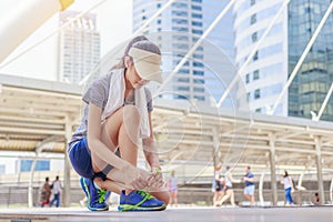 Beautiful girl tying shoe laces before running outdoors