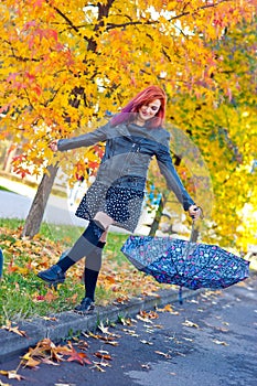 Beautiful girl with umbrella in autumn scene