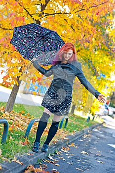 Beautiful girl with umbrella in autumn scene