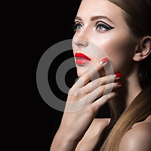 Beautiful girl with unusual black arrows on eyes and red lips and nails. Beauty face.