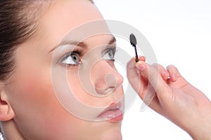 Beautiful girl using eye lash separator brush
