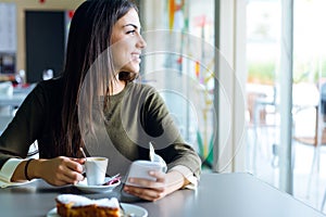 Beautiful girl using her mobile phone in cafe.