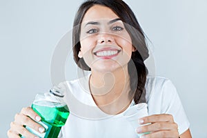 Beautiful girl using mouthwash. Isolated on white.