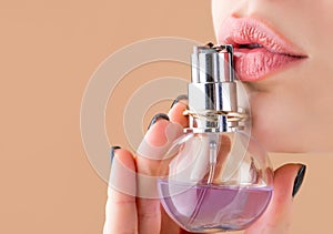 Beautiful girl using perfume. Woman with bottle of perfume. Woman presents perfumes fragrance. Woman perfumes bottle