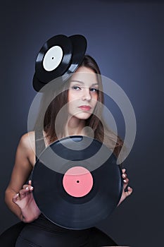Beautiful girl with vinil disc on black background photo