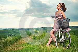 Beautiful girl with vintage bike outdoor, Tuscany summer time