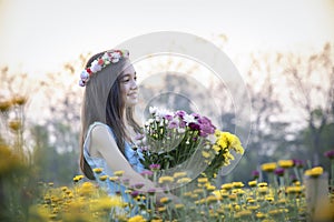 Beautiful girl in vintage dress and hat standing near colorful flowers