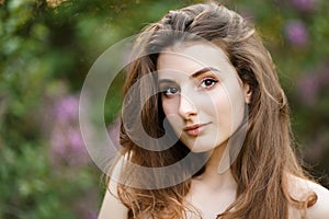 Beautiful girl in a vintage dress in spring lilac garden