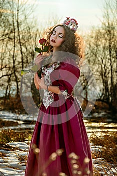 Beautiful girl in vintage red dress with a rose