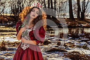 Beautiful girl in vintage red dress with a rose