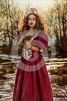 Beautiful girl in vintage red dress with a rose