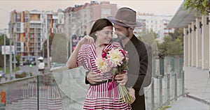 Beautiful girl waiting for her lover who sneaks up with a bouquet of flowers behind