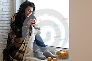 beautiful girl waiting for love sitting on the windowsill wrappe