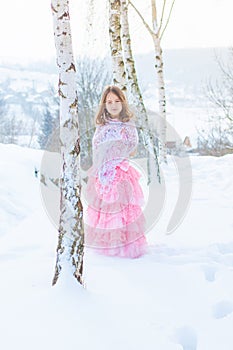 A beautiful girl walks on a frozen forest covered with snow