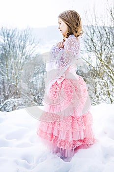 A beautiful girl walks on a frozen forest covered with snow