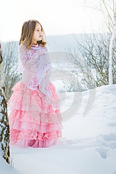 A beautiful girl walks on a frozen forest covered with snow