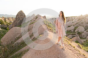 a beautiful girl walks on the top of the mountain enjoying the view