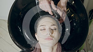 Beautiful girl washes her hair before a haircut in a beauty salon. hair washing at a hairdressing, young caucasian girl