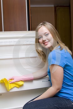 Beautiful girl washes refrigerator