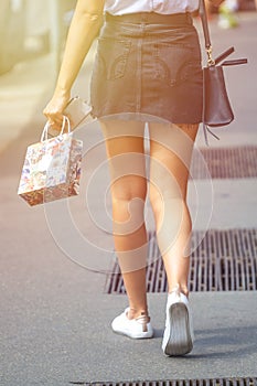 Beautiful girl wearing black mini dress and walking on Milan cit