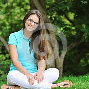 Beautiful girl wearing glasses and smiling - outdoor portrait