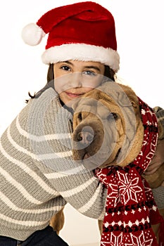 Beautiful girl wearing a santa hat hugging a Shar Pei dog