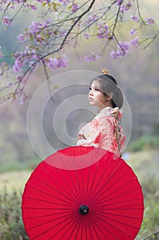 Beautiful girl wearing traditional japanese kimono holding umbrella with cherry blossom, Japan. Asian woman tourists