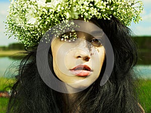 Beautiful girl wearing a wreath of wildflowers